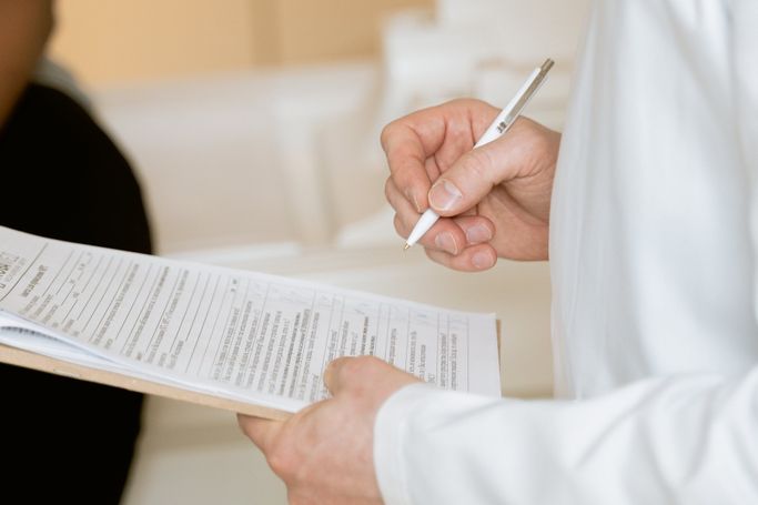 Mann mit Stift und Blatt in der Hand schreibt 